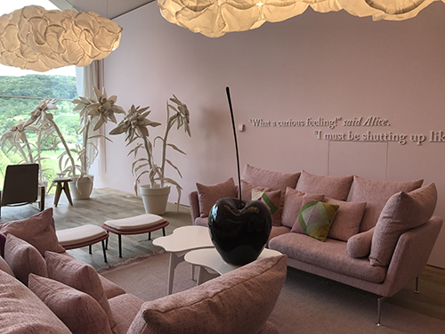 a light pink interior with pink couches and cloud like light fixtures