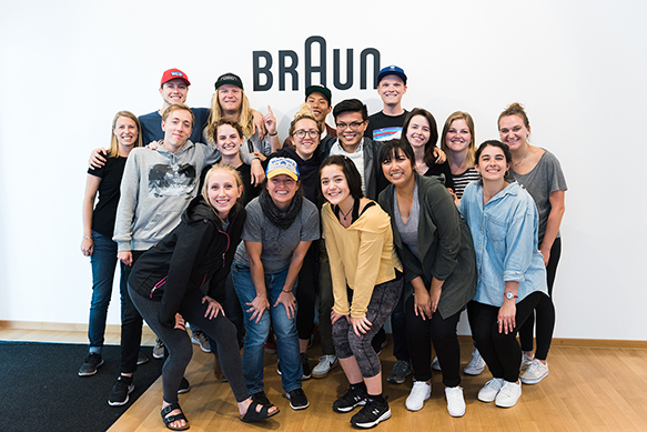 A group of students pose together in front of a 'braun' sign
