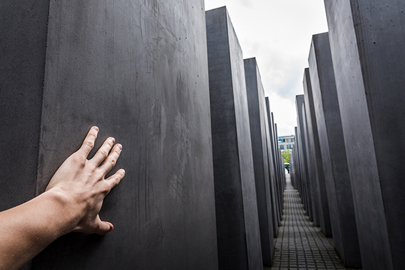 a hand touches one of the monuments at the memorial