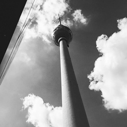 an angled black and white photo of a tv tower