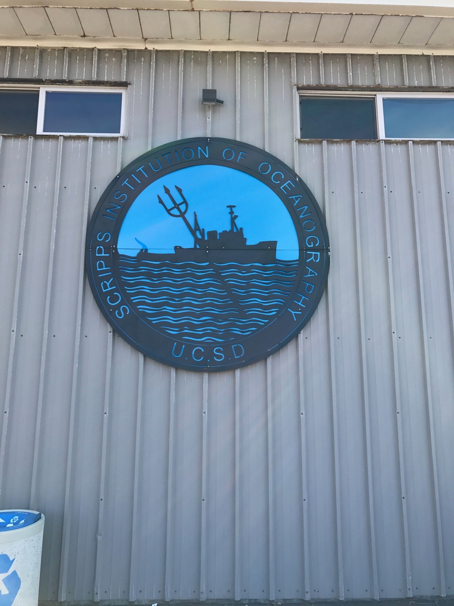 circular Scripps emblem including graphic ship with trident crossing the circle