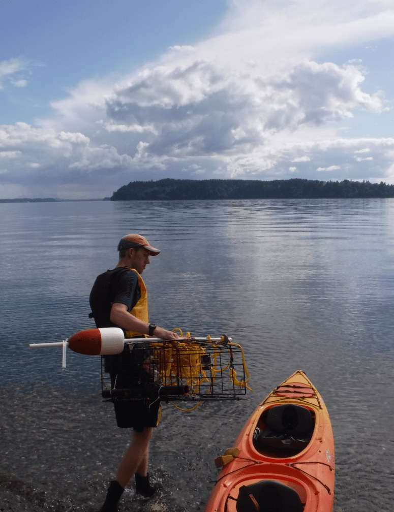 Spencer Johnson with research equipment packing up a kayak.