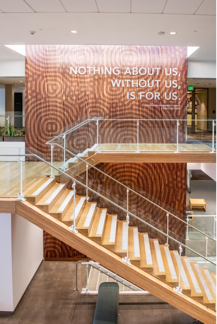 Stairway in the multicultural center, with text on the wall reading "Nothing about us without us is for us"