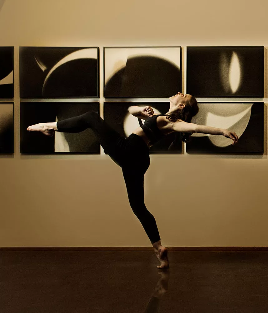 dancer in black in front of black and white abstract photographs