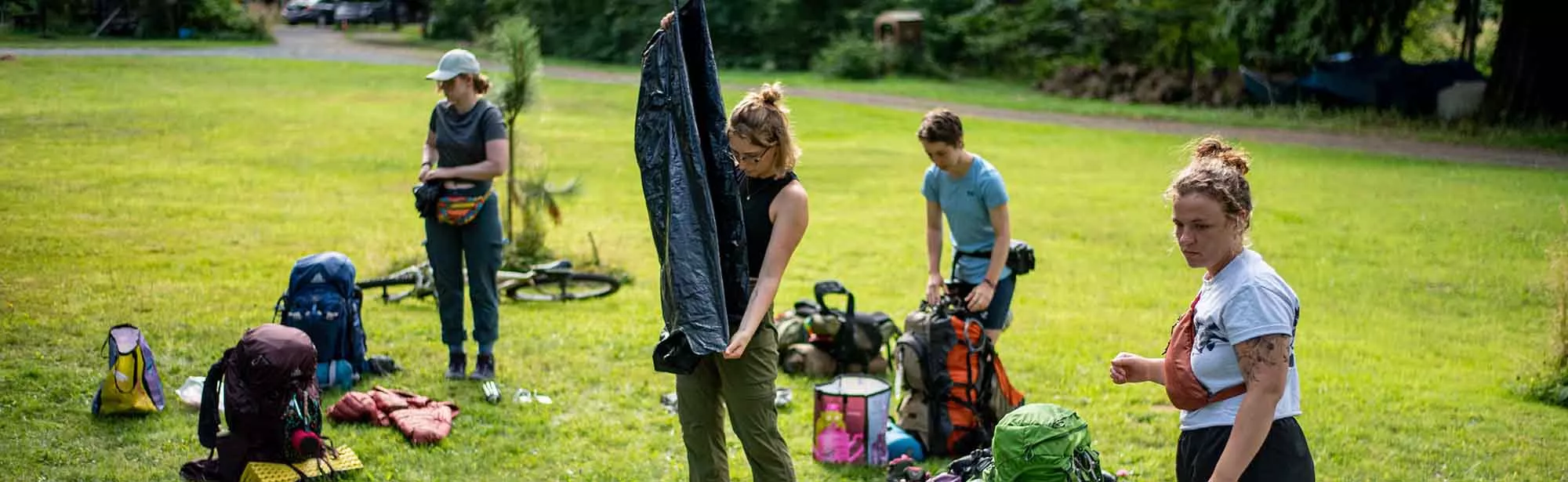 Students unpacking camping gear in a field