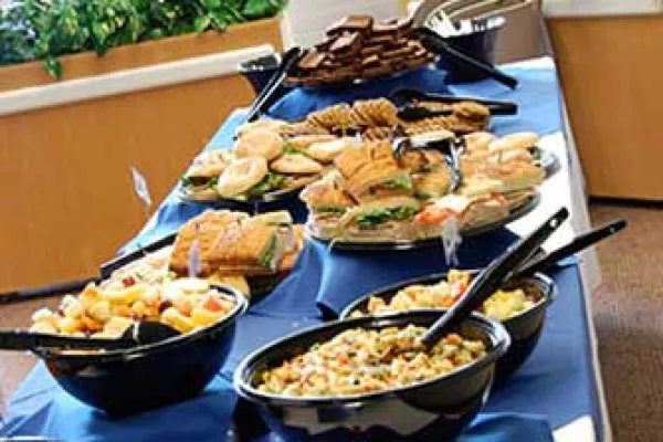 A full buffet of delicious foods is formally laid out across a table.