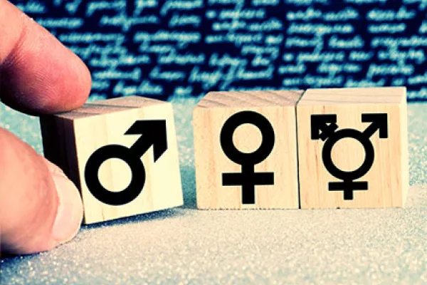 Close up of small wooden tiles with different gender symbols.