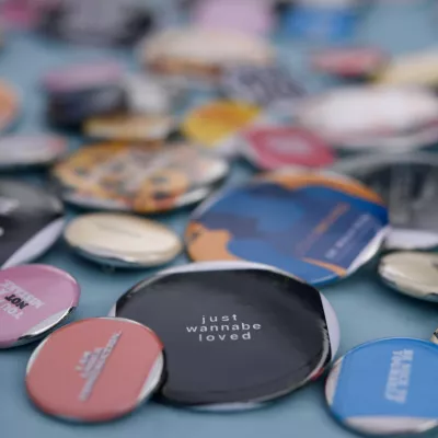 Close-up of several round pins with different phrases and words of encouragement on them.