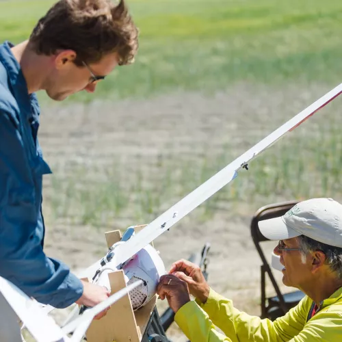 A student and instructor work on equipment in the field.