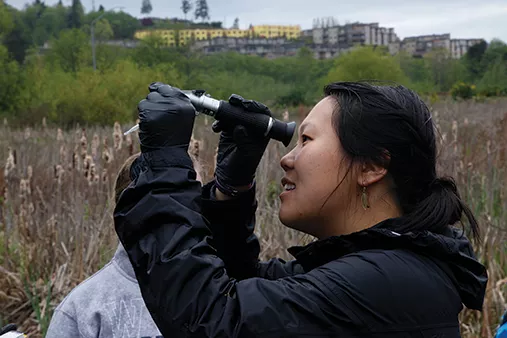 Huxley student Kimberly Diep looks through a refractometer.