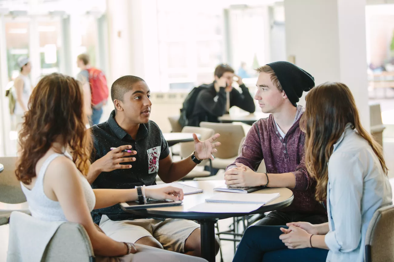A group of students having a discussion at a table in the Viking Union.