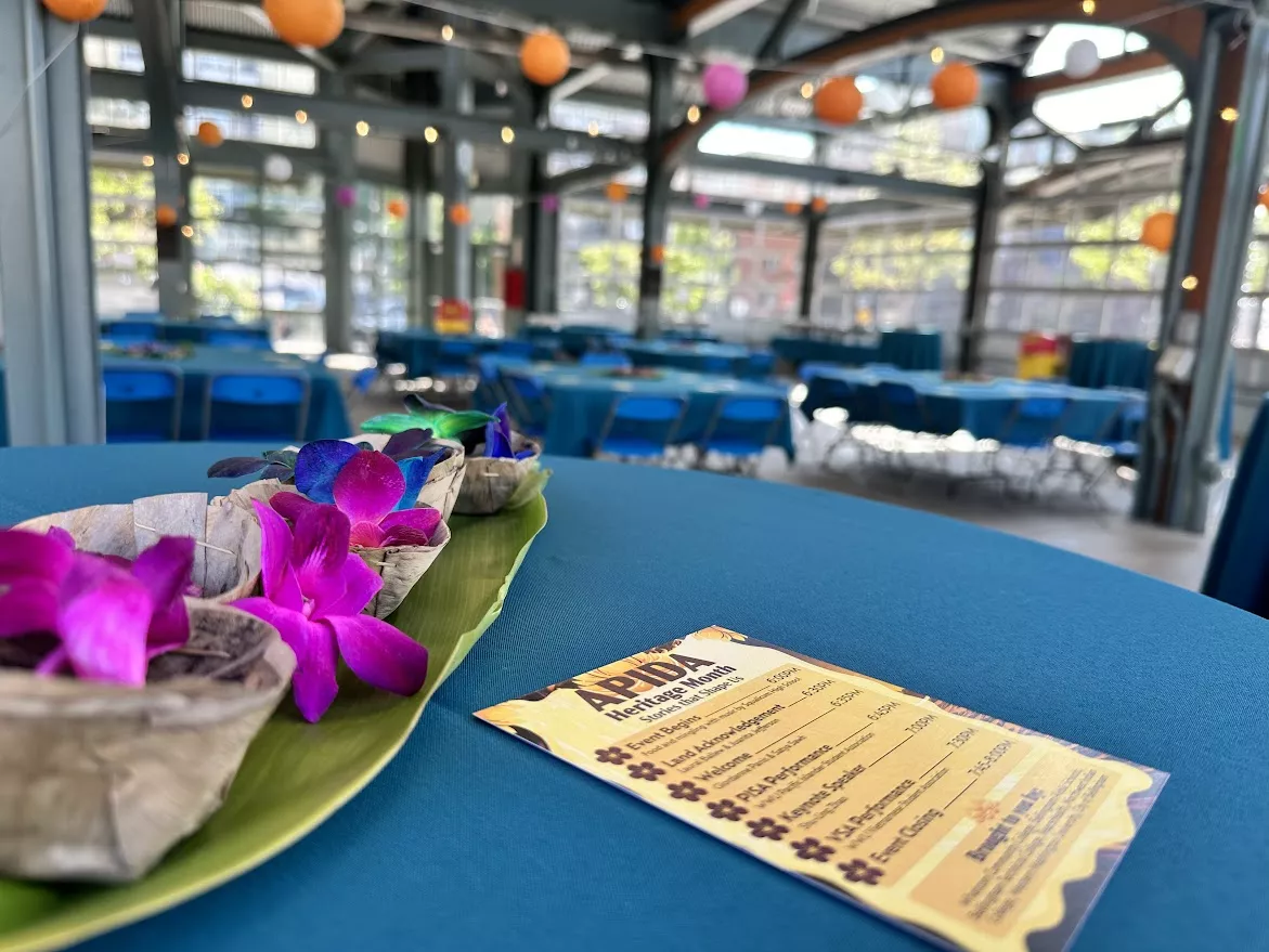 schedule of events from 2023's APIDA festival on a table with bright, magenta flowers
