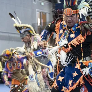 Native American men in traditional dress dancing at a Powwow